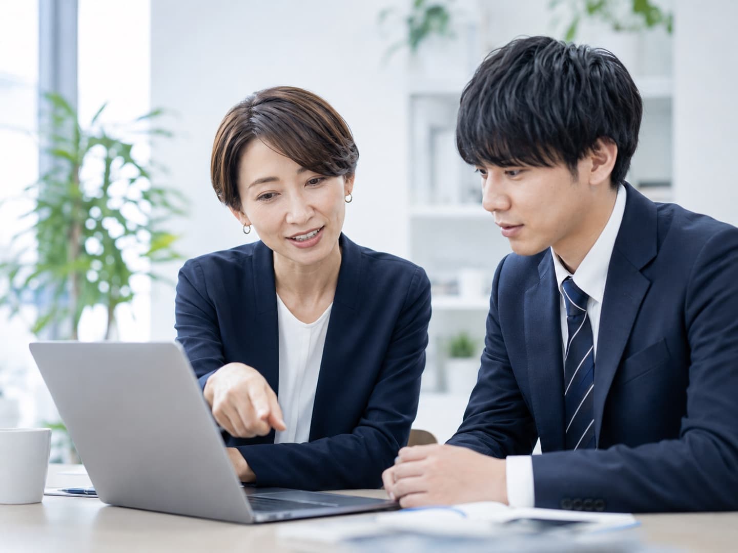 メンバーと画面を見ながら状況を確認している女性マネージャー