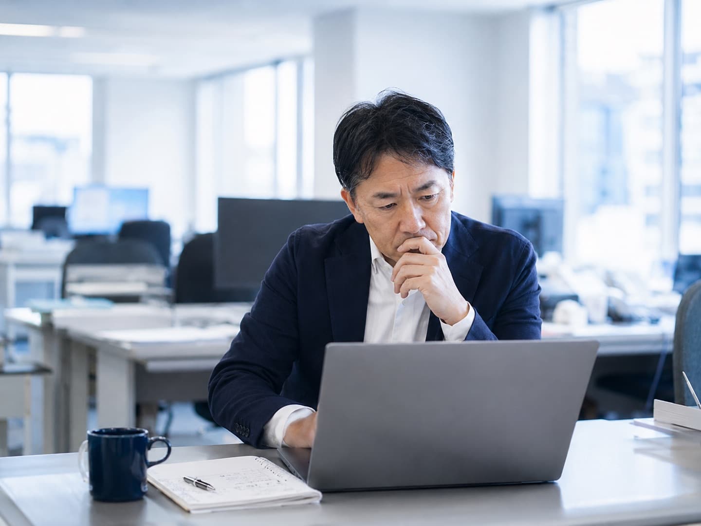 朝のオフィスで数字を確認している中小企業の経営者